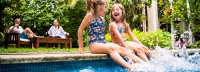 Pool für Zuhause kaufen, Kinder beim Planschen, Eltern im Hintergrund